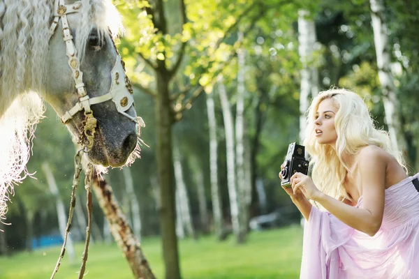 Beautiful woman taking pictures of the horse — Stock Photo, Image