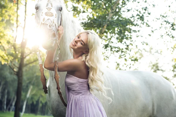 Mujer satisfecha abrazando caballo blanco — Foto de Stock