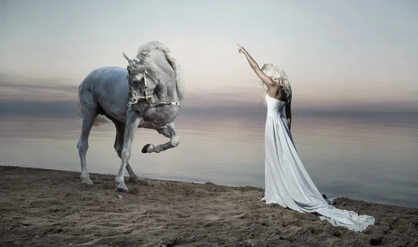 Стройная женщина, стоящая напротив лошади — стоковое фото