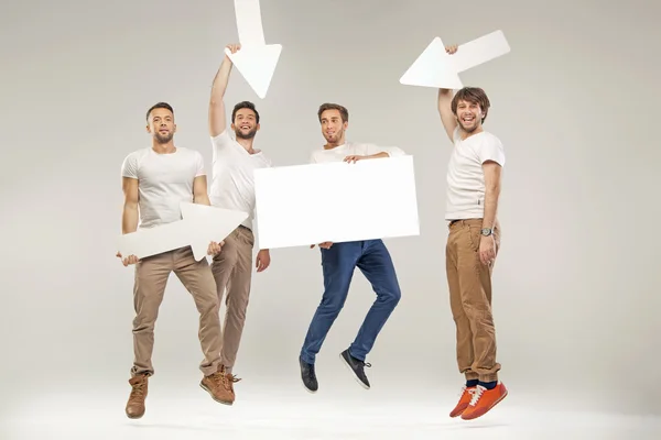 Guapos estudiantes saltando con símbolos — Foto de Stock