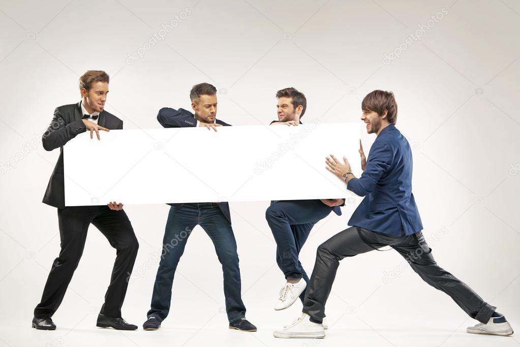 Four guys pushing the billboard