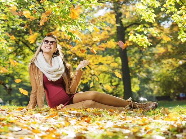 Intelligente signora guardando autunno foglie — Foto Stock