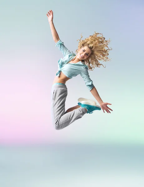 Atlama ve dans kıvırcık saçlı sporcu kadın — Stok fotoğraf