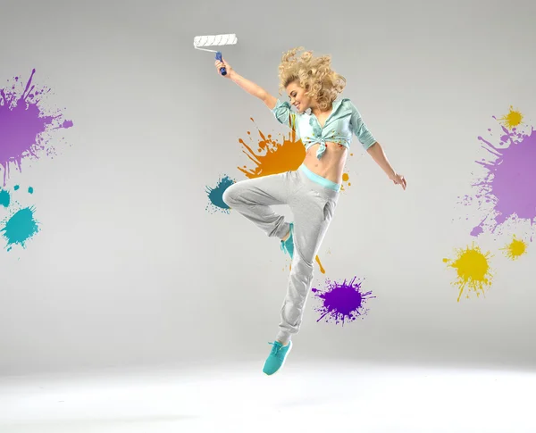 Menina alegre segurando um rolo de pintura — Fotografia de Stock