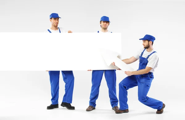 Three handsome builders holding signs — Stock Photo, Image