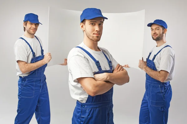 Tres empleados guapos sosteniendo una tabla — Foto de Stock