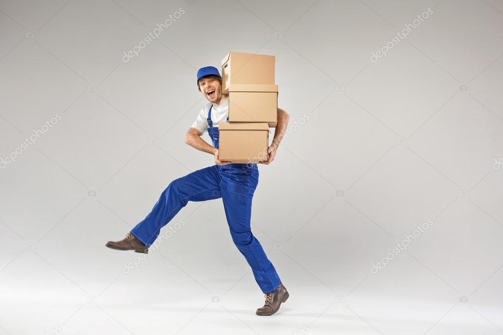 Laughing young builder holding boxes