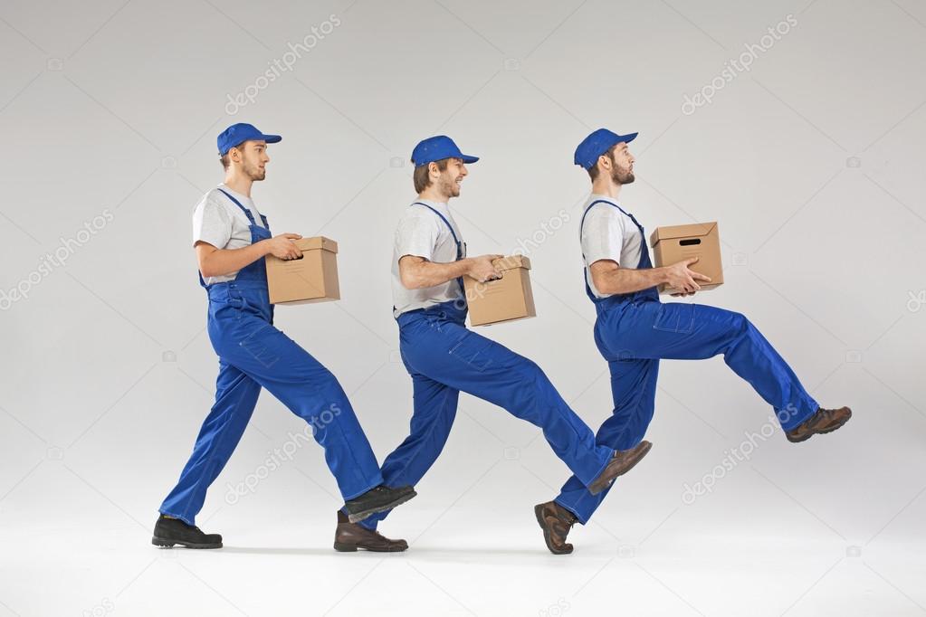 Three guys walking with boxes