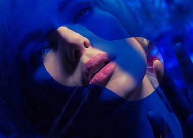 Mavi duvarın arkasında şehvetli genç kadın