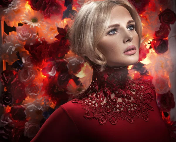 Closeup portrait of a woman with flowers behind — Stock Photo, Image