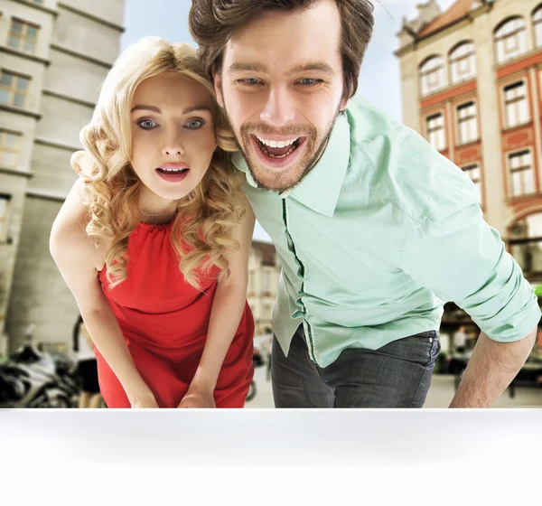 Pareja sorprendida mirando la ventana de la tienda — Foto de Stock