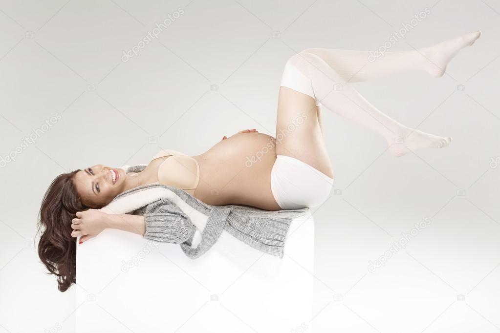 Cheerful pregnant woman stroking her belly