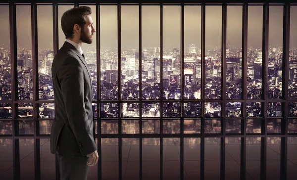 Элегантный бизнесмен на вершине небоскреба — стоковое фото
