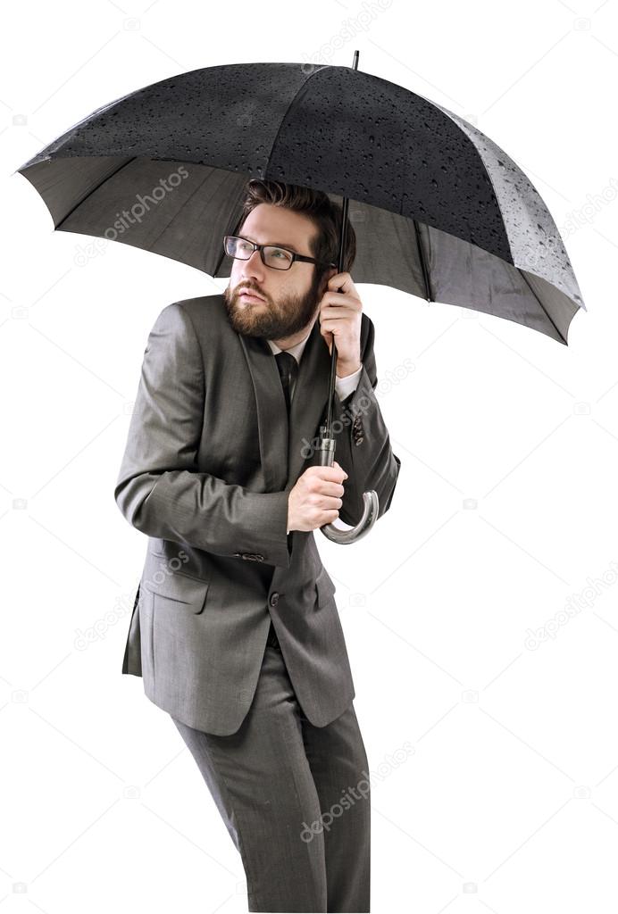 Afraid businessman hiding himself under the umbrella