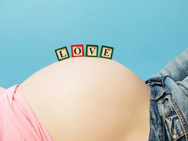Letter boxes on pregnant woman belly — Stock Photo, Image