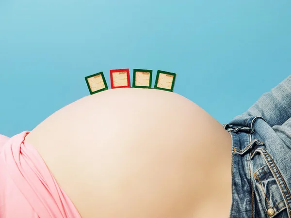 Letter boxes on pregnant woman's belly — Stock Photo, Image