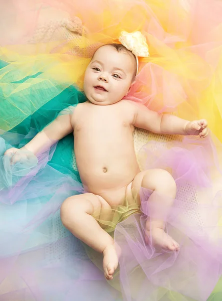 Cute little toddler lying on colorful floor — Stock Photo, Image