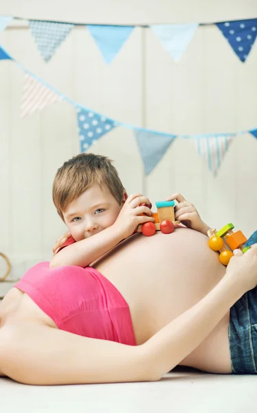 Cute boy playing with the unborn sibling — Stock Photo, Image