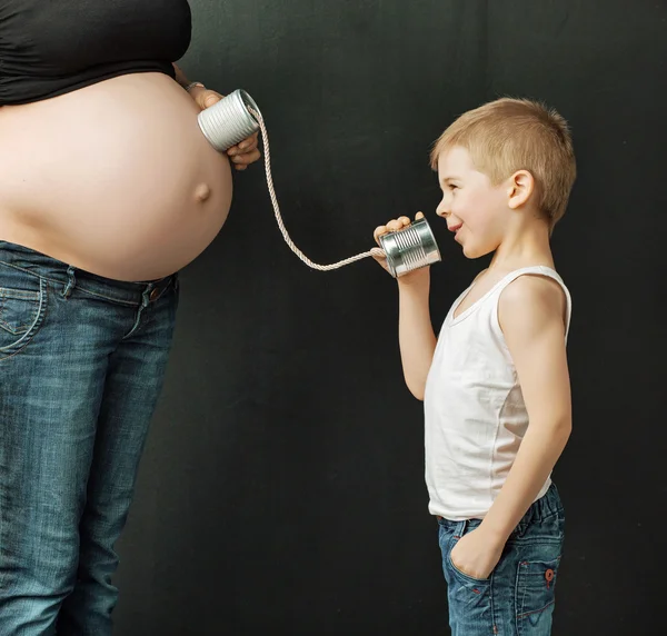 Концептуальное изображение ребенка, разговаривающего с нерожденным братом — стоковое фото