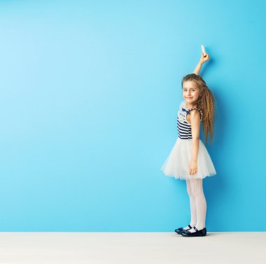 Sevimli kız tebeşir duvar üzerinde yazma