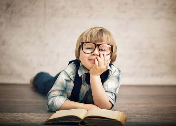 Умный мальчик, читающий книгу — стоковое фото