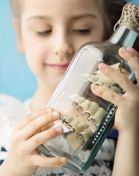 Girl holding a ship in the bottle — Stock Photo, Image