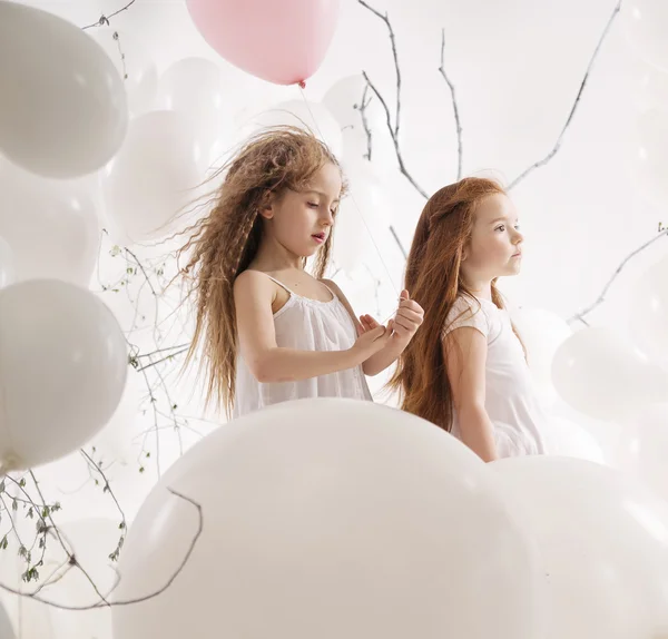 Две милые девушки среди воздушных шаров — стоковое фото