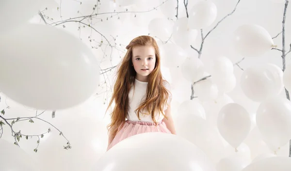 Menina bonito entre balões brancos — Fotografia de Stock