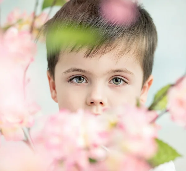Knappe kleine man met een bloem — Stockfoto