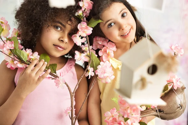 İki sevimli kız pembe çiçekli — Stok fotoğraf