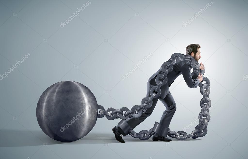 Tired businessman dragging heavy chains — Stock Photo © konradbak 74054269