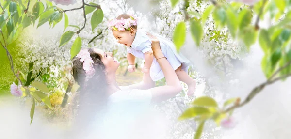 漂亮妈妈和小宝宝放松在一个春天的果园 — 图库照片