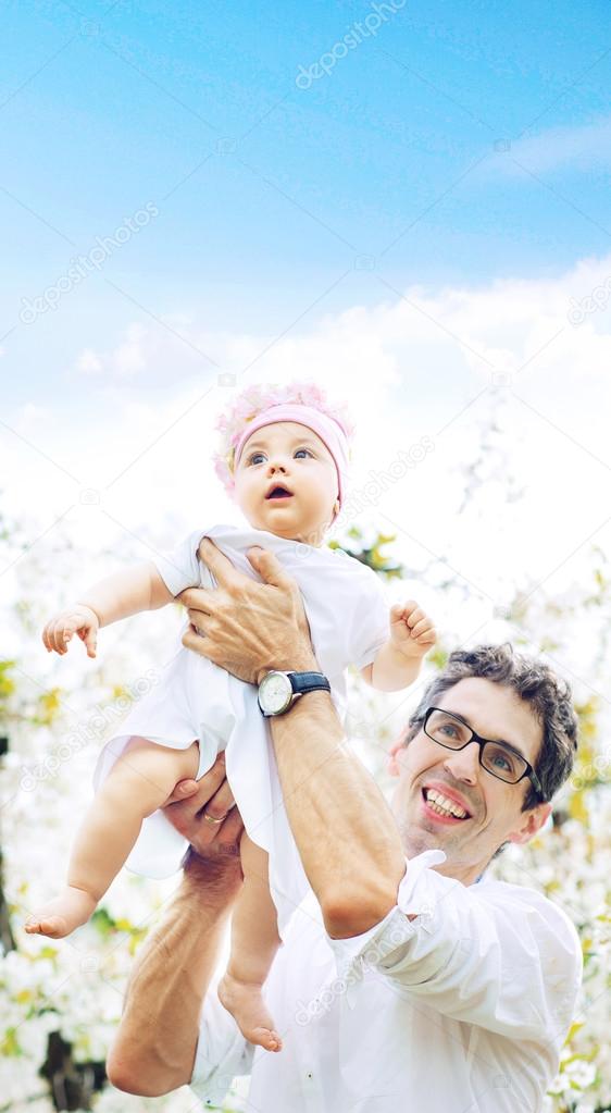 Cheerful father holding his lovely baby