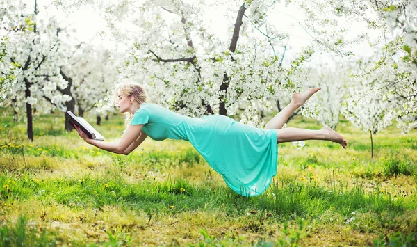 Entzückende Frau schwebt während der Buchlesung — Stockfoto