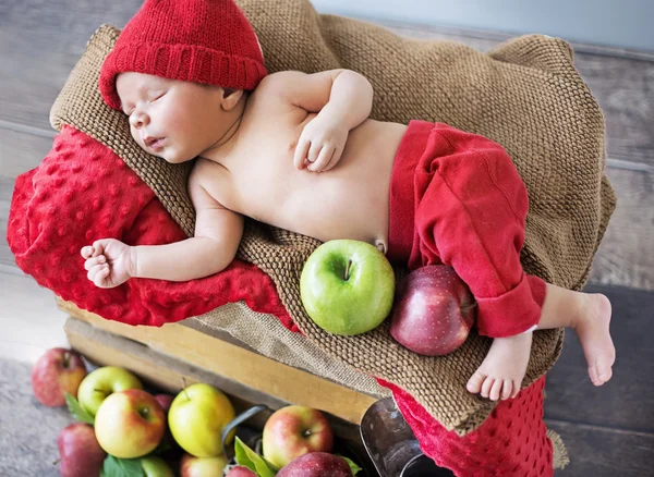 Newborn child sleeping on the box of apples — Stock Photo, Image