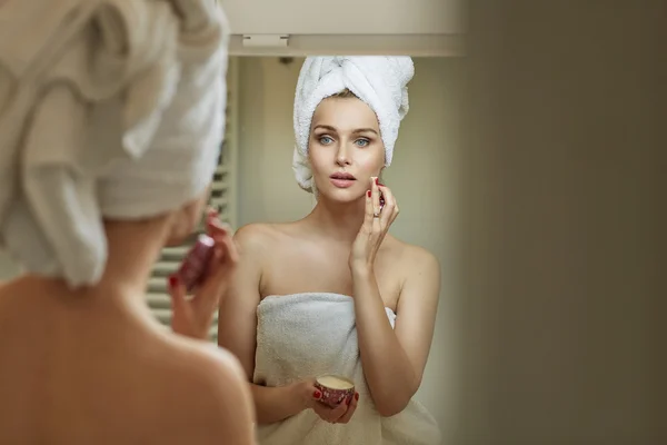 Mulher loira esfregando suavemente um creme — Fotografia de Stock