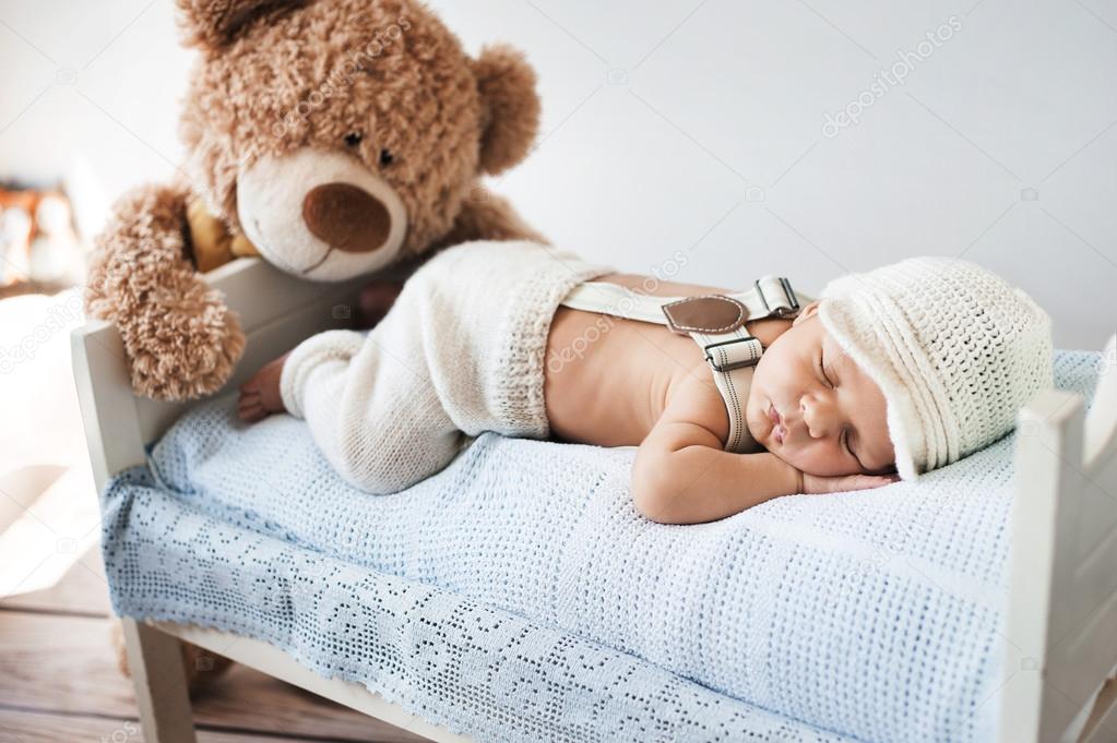 Little baby sleeping with a teddy bear