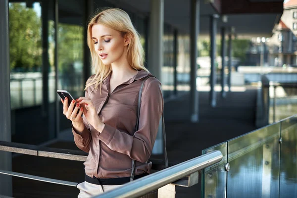 Blonde Dame benutzt ihr Smartphone — Stockfoto