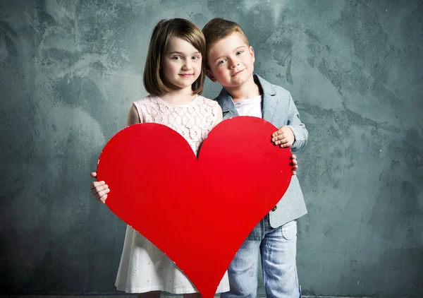 Dos niños sosteniendo un corazón gigante —  Fotos de Stock