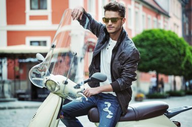 Scooter üzerinde yakışıklı bir genç adam portresi