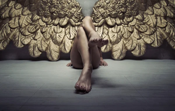 Изображение золотого ангела, отдыхающего на полу — стоковое фото