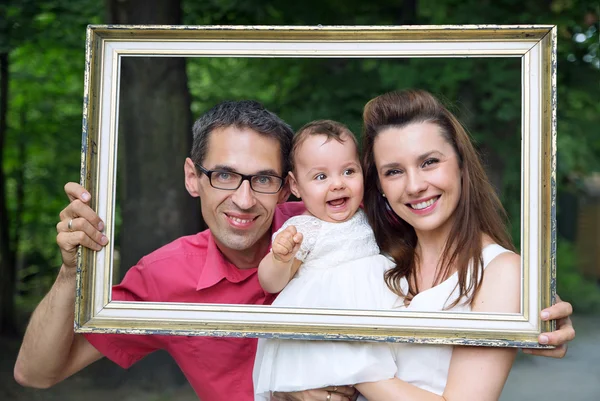 Familia alegre posando con el marco —  Fotos de Stock