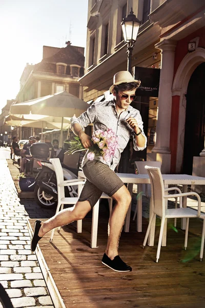 Joven corriendo y sosteniendo rosas — Foto de Stock