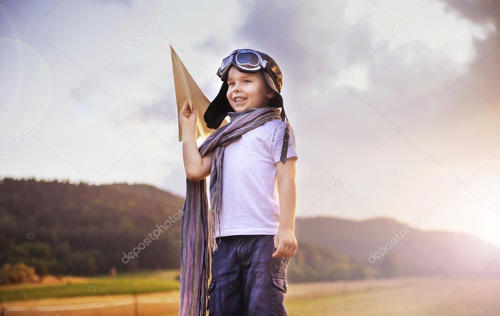 Cute little pilot holding a toy plane