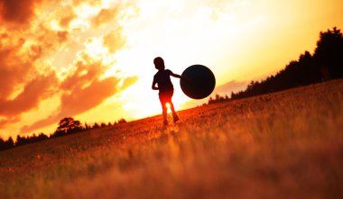 Küçük çocuk futbol oynarken çayır on