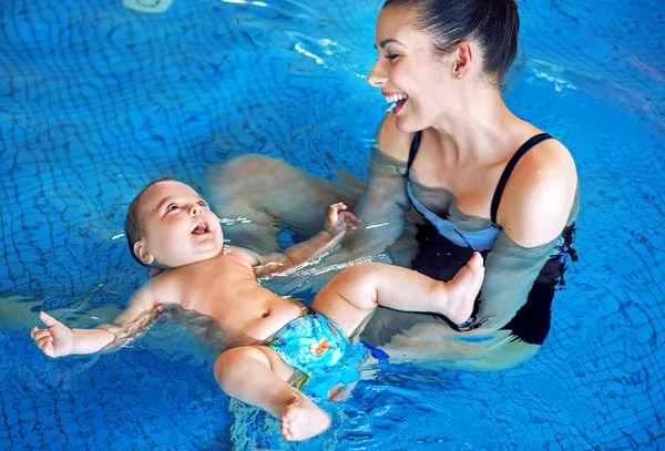 年轻的母亲和婴儿放松在游泳池里 — 图库照片