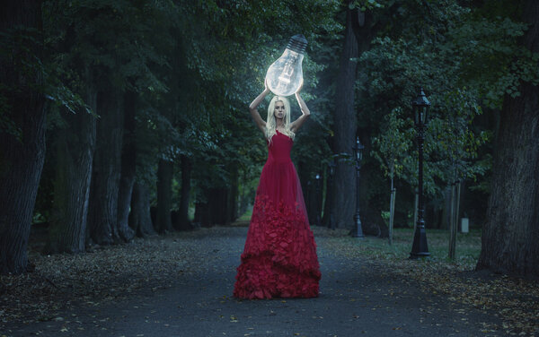 Art photo - stunning blond beauty hodling a big lightbulb