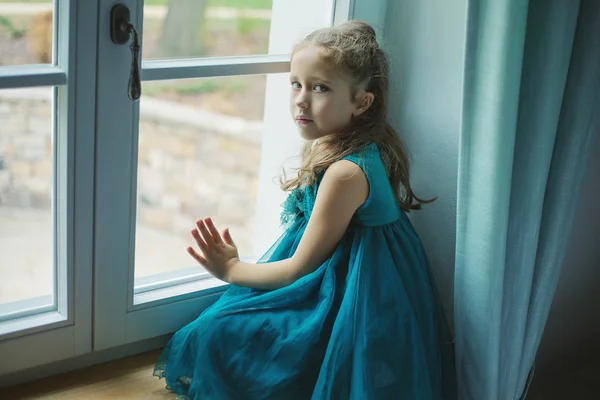Ledsna barn tittar genom fönstret Stockfoto