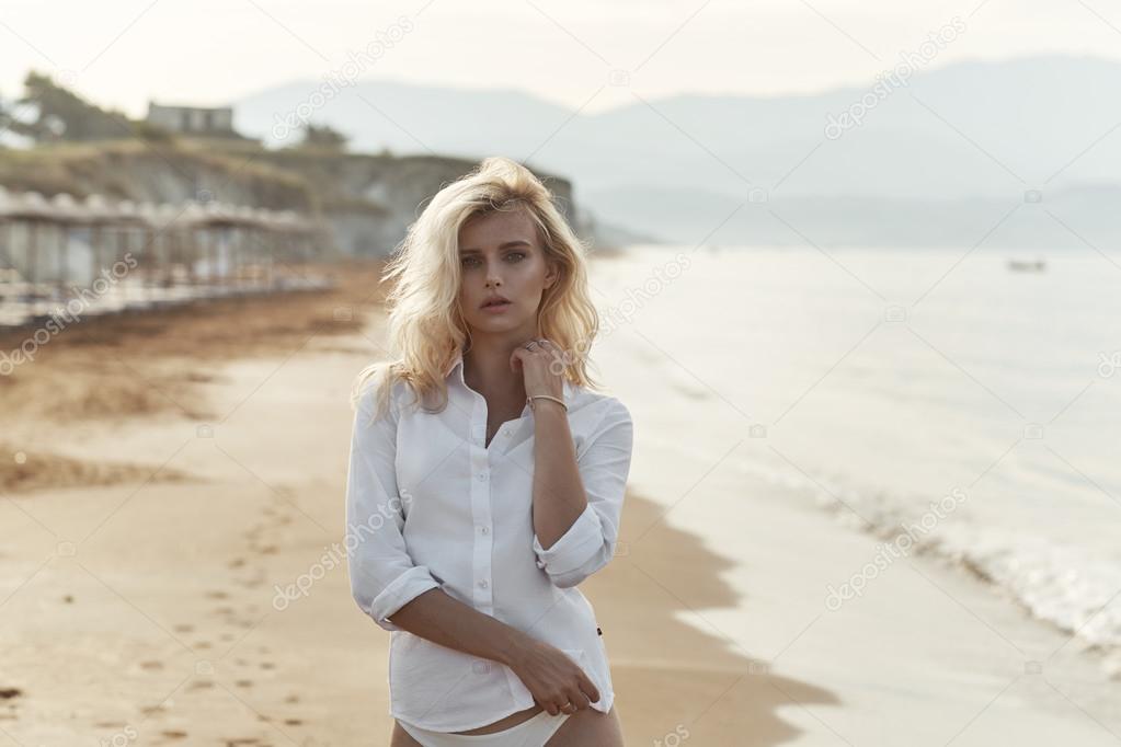 Sensual blond lady walking on the tropical beach