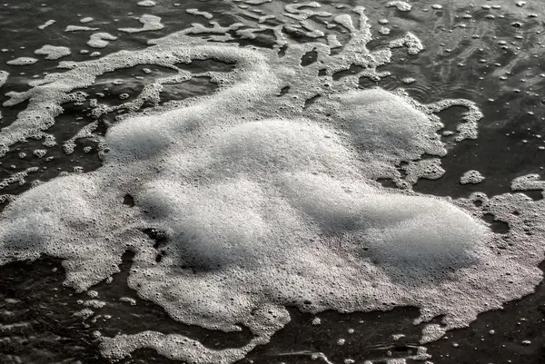 Пузырьки пены плавают в морской воде — стоковое фото